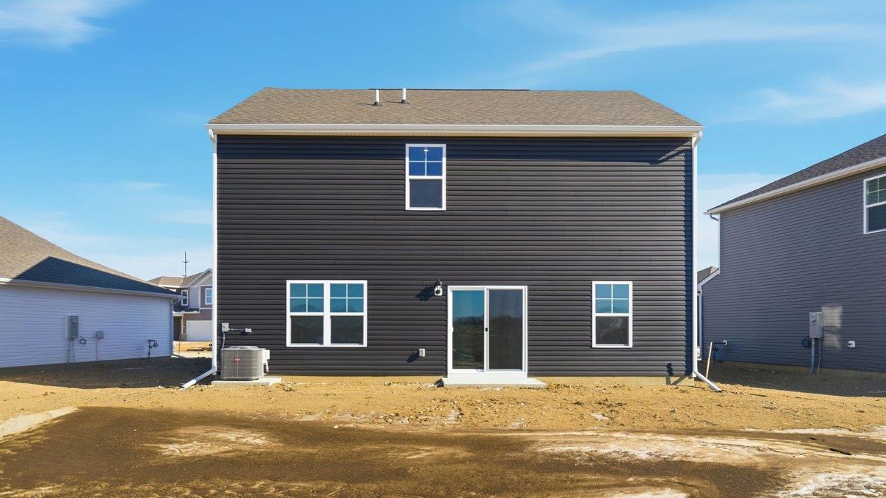 rear exterior of two story home with grey siding