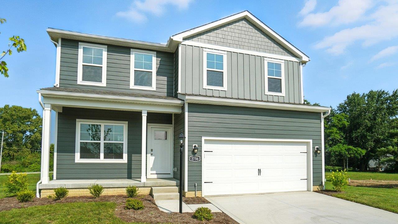two story home with grey siding, covered front porch and two car garage
