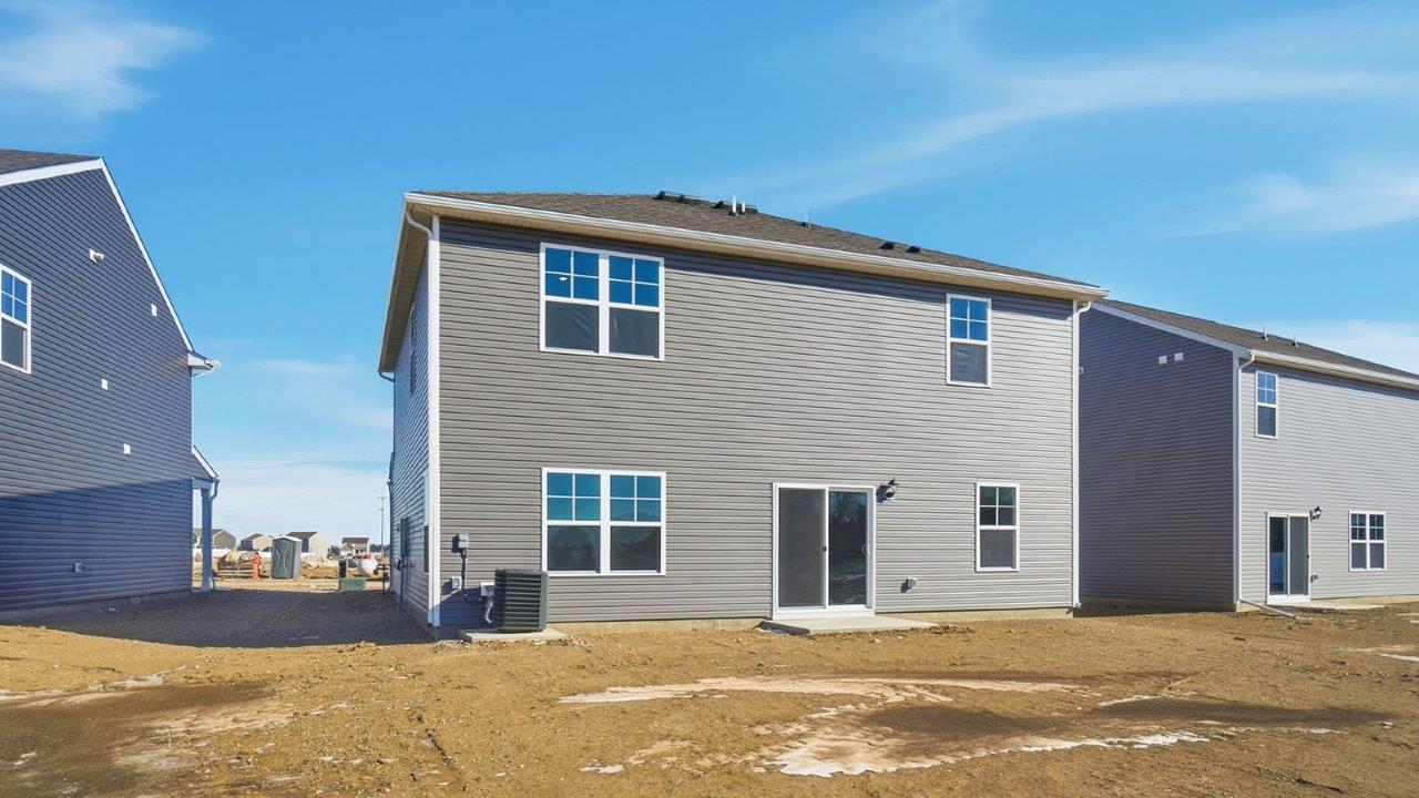rear exterior of two story home with grey siding