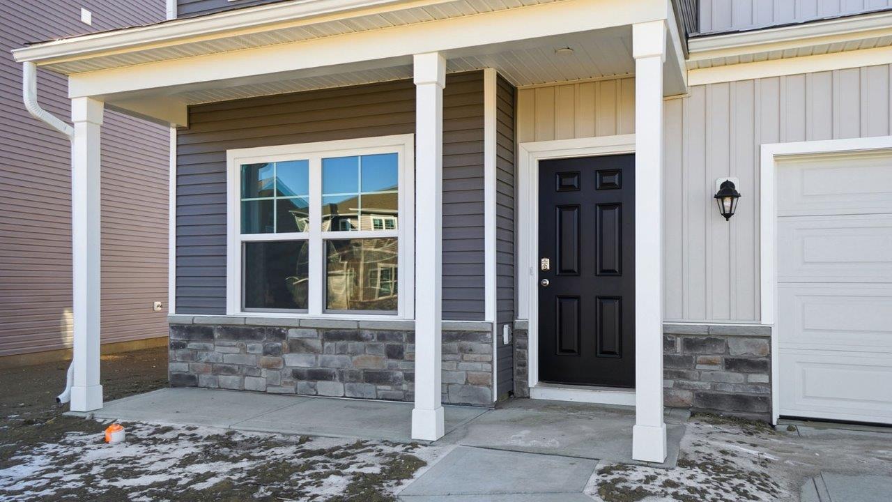 covered front porch with stone water table, window and black front door