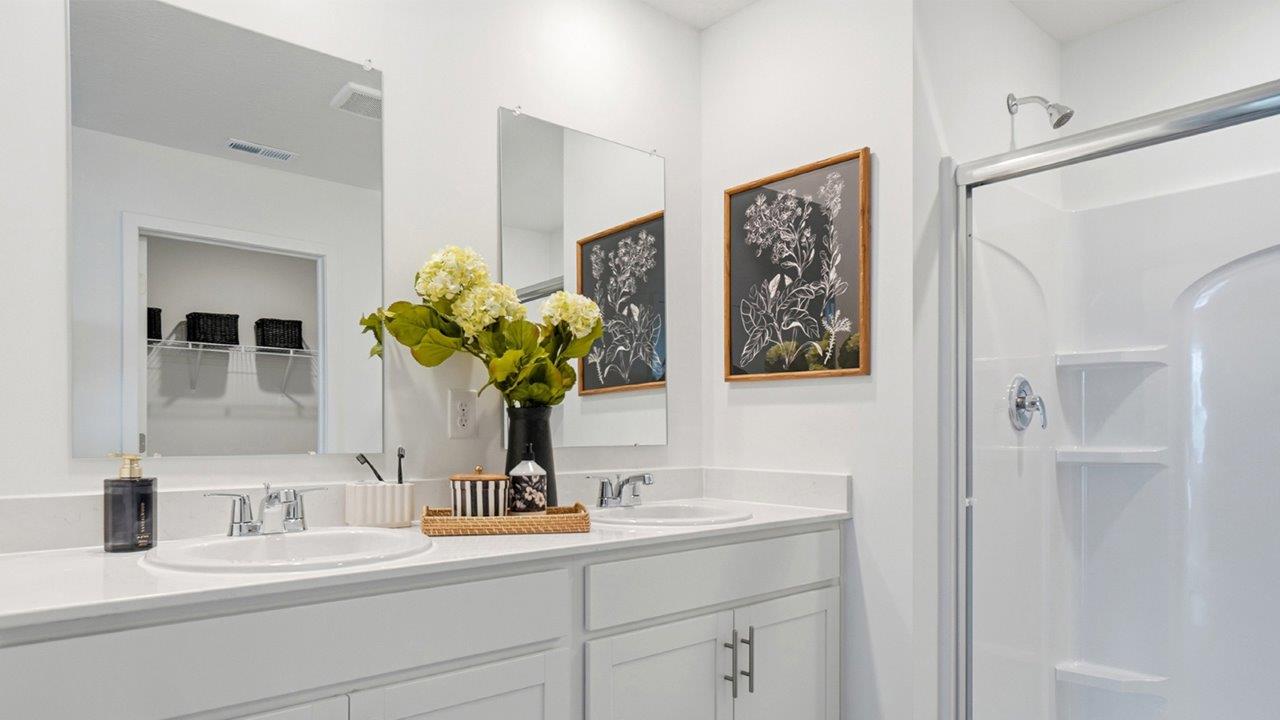 primary ensuite bathroom with double vanity and walk in shower