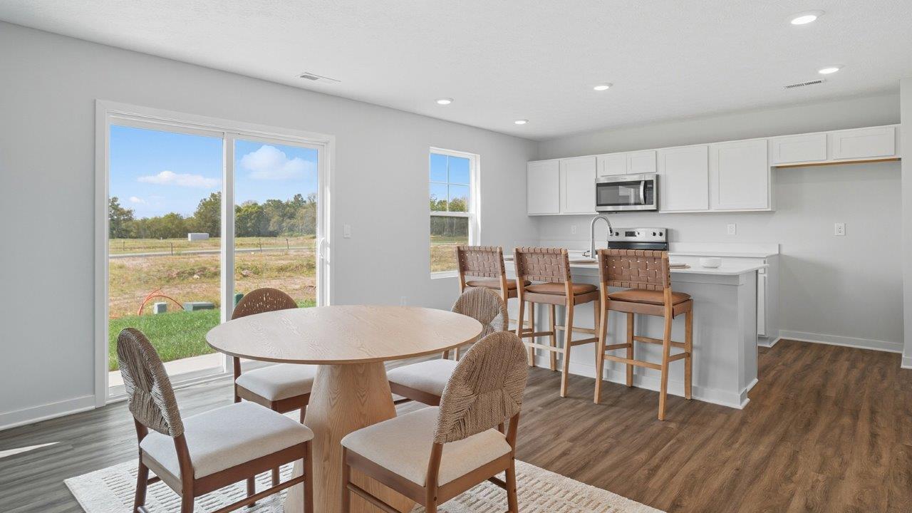 round dining table with chairs, rear sliding door and kitchen