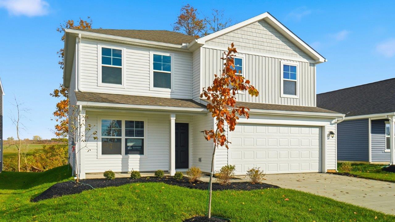 two story home with white siding, covered front porch and two car garage