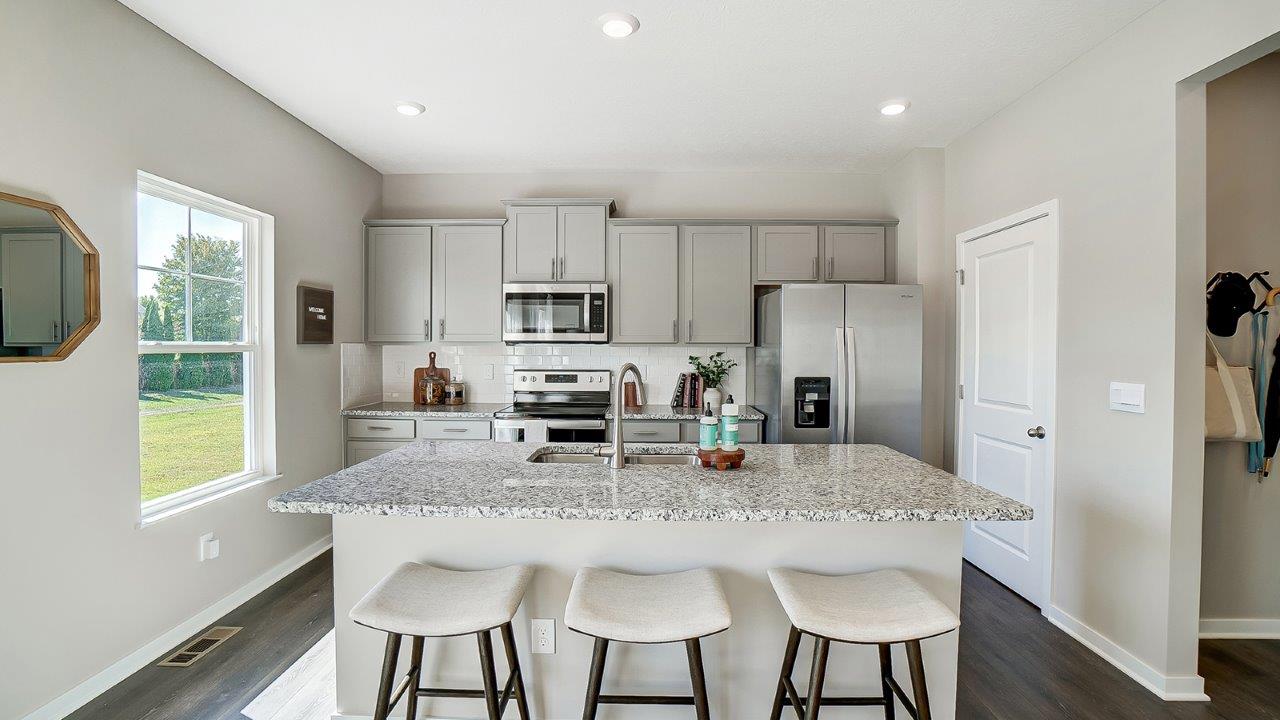 kitchen with grey cabinets, hard surface counters, stainless steel appliances, walk in pantry