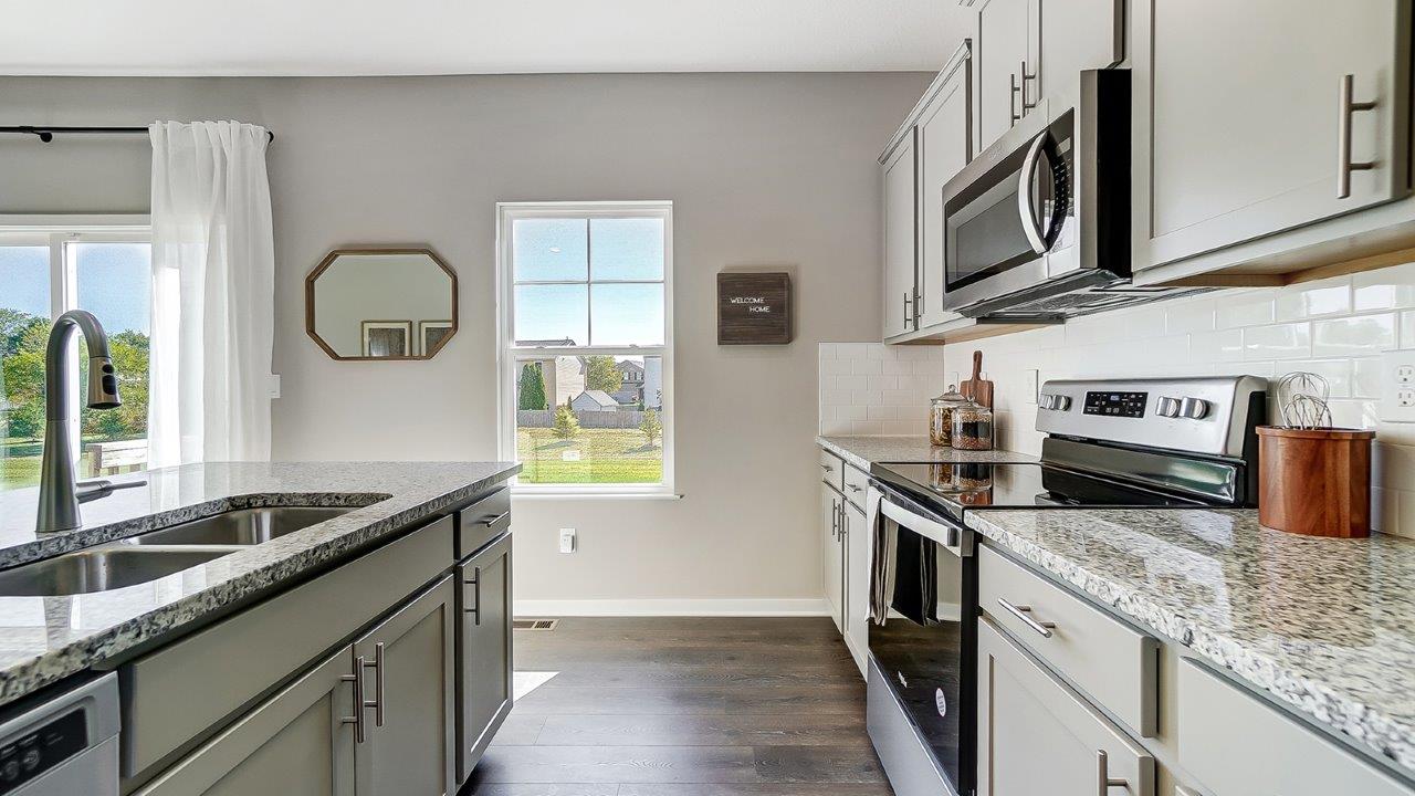 kitchen with grey cabinets, hard surface counters, stainless steel appliances, single window