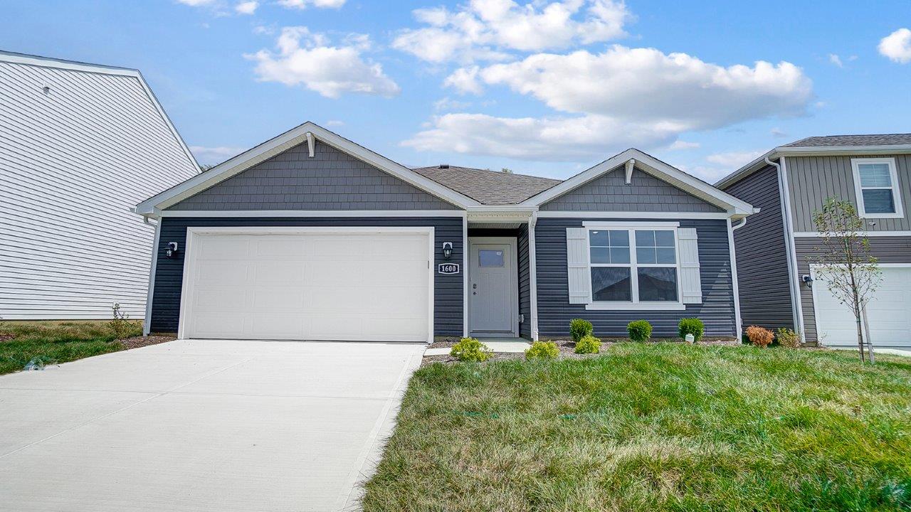 single story home with grey siding, covered entry and two car garage