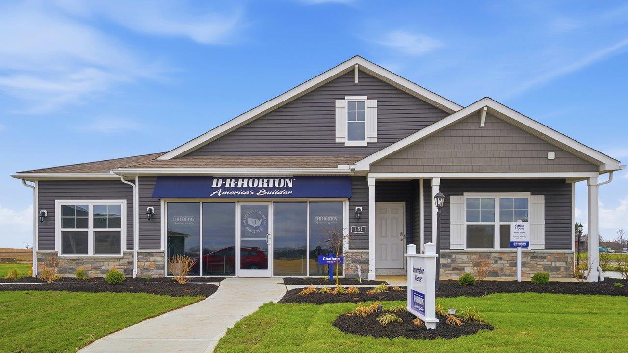 single story model home with glass storefront, covered front porch and three car garage