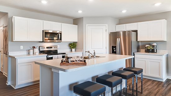 kitchen with white cabinets, built in island, hard surface counters, corner walk in pantry, stainless steel appliances