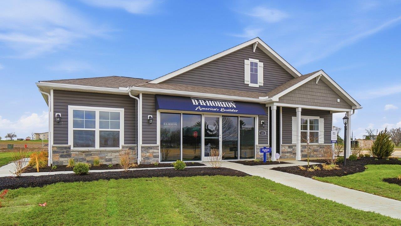single story model home with glass storefront, covered front porch and three car garage