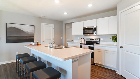 kitchen with white cabinets, built in island, hard surface counters, corner walk in pantry, stainless steel appliances