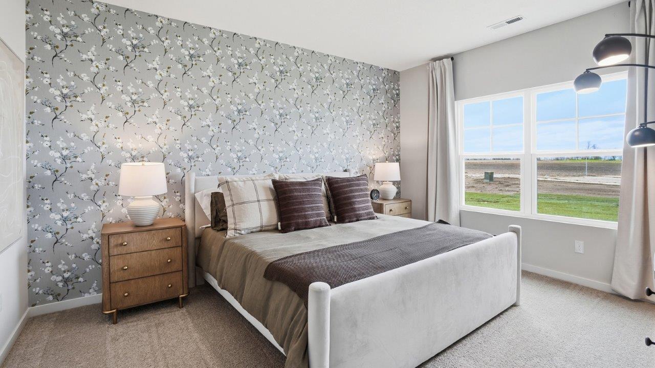 furnished primary bedroom with double window