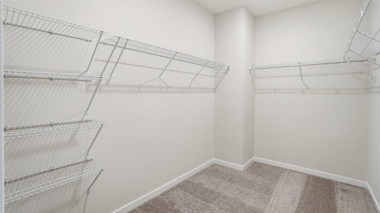 primary walk in closet with ventilated shelving