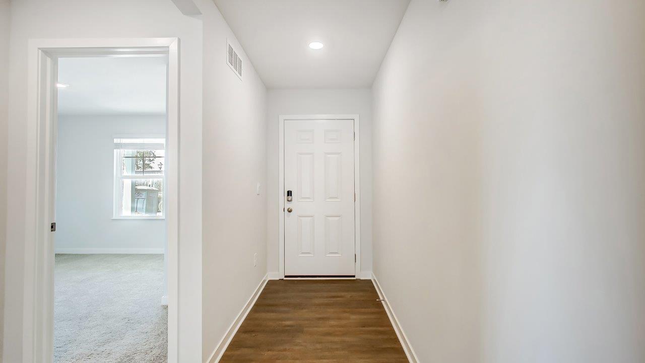 foyer with hard surface floors, front bedroom entry