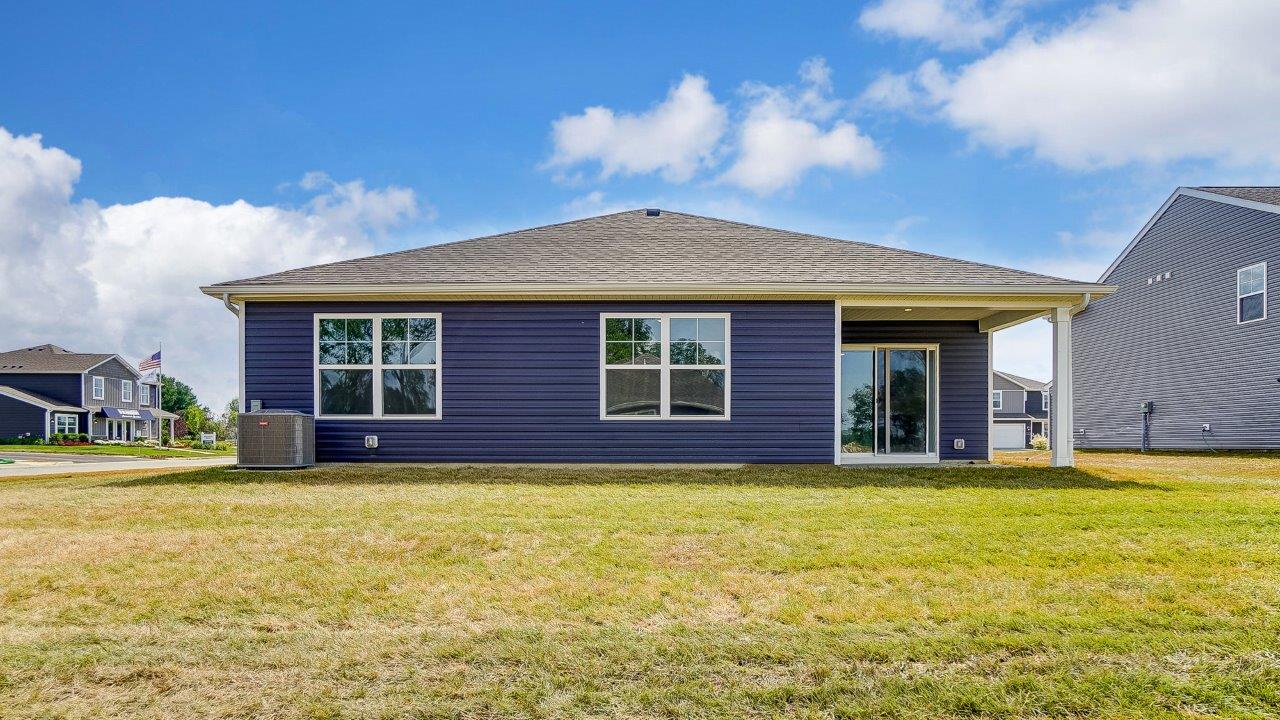 single story home with blue siding rear exterior with covered back patio