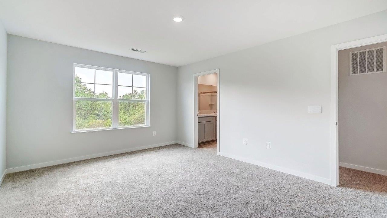 primary bedroom with double window, entry and ensuite bath
