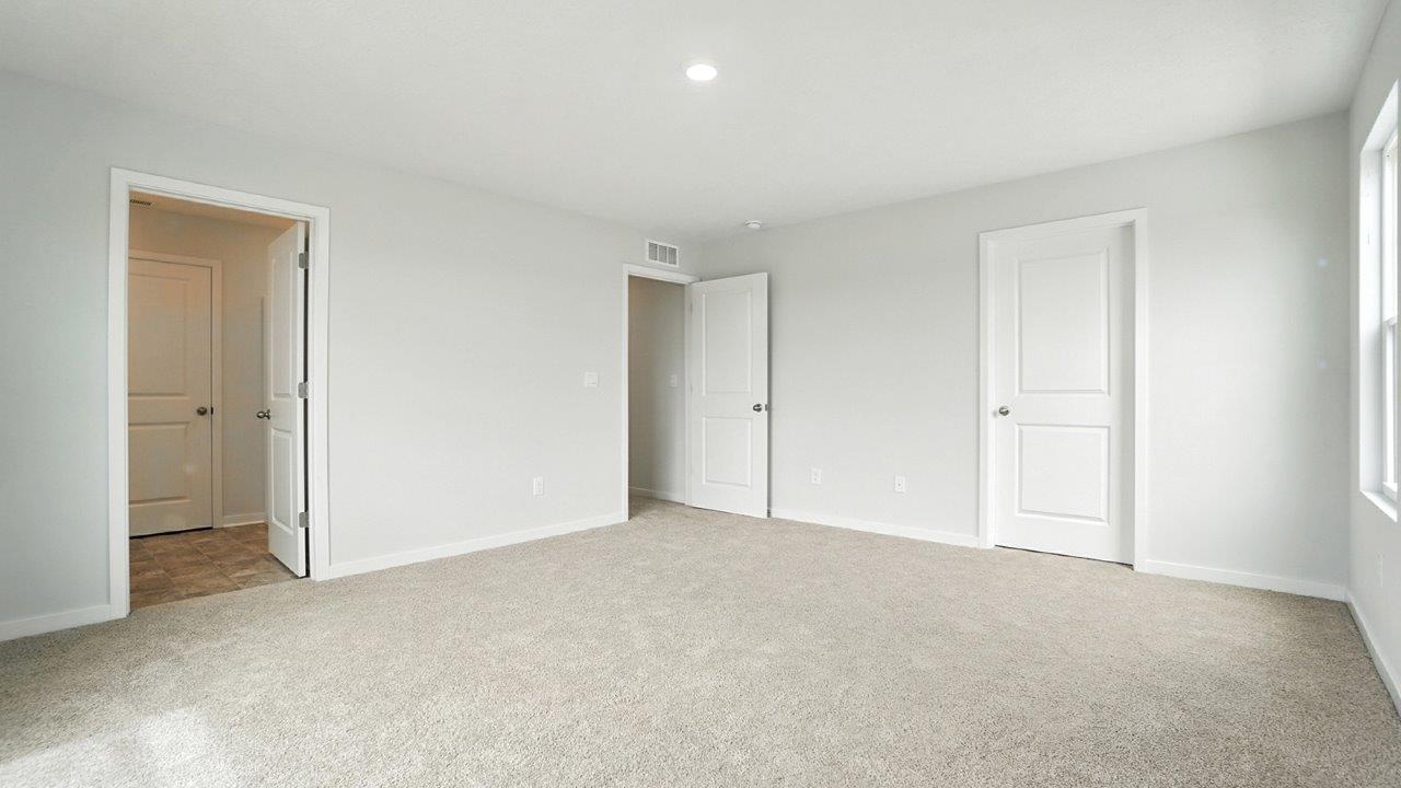 primary bedroom with ensuite bath, closet and entry