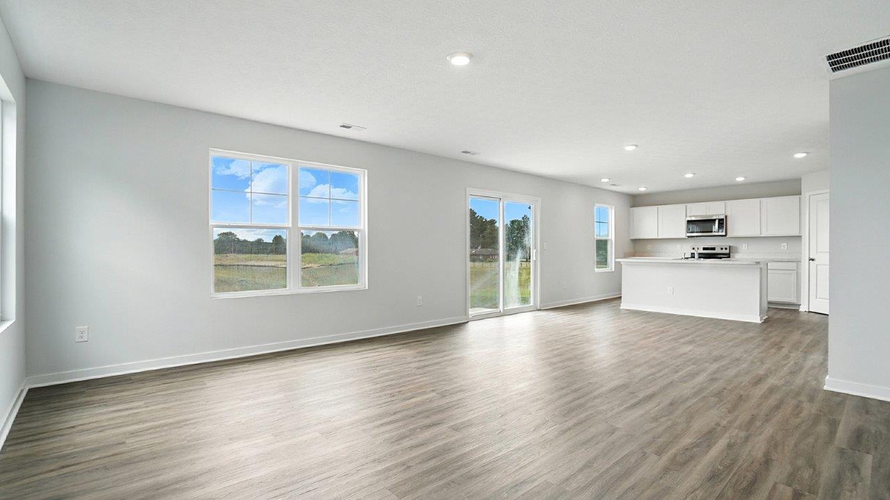 great room with double window, rear sliding door and kitchen