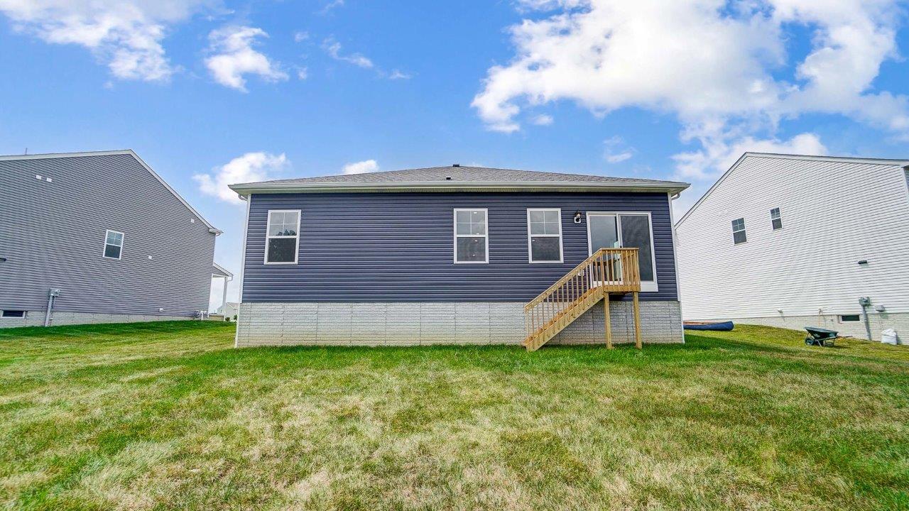 single story home with blue siding rear exterior with steps to grade