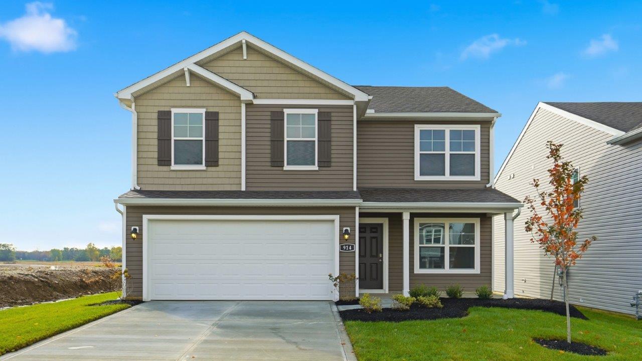 two story home with brown siding, covered front porch, two car garage