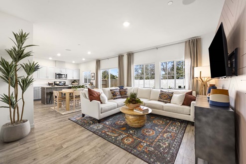 Amber Lynn Estates Plan 1547 Open concept living and dining area with view of kitchen and back patio door.