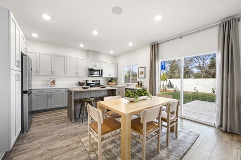 Amber Lynn Estates Plan 1547 Open concept kitchen and dining area and back patio sliding door.