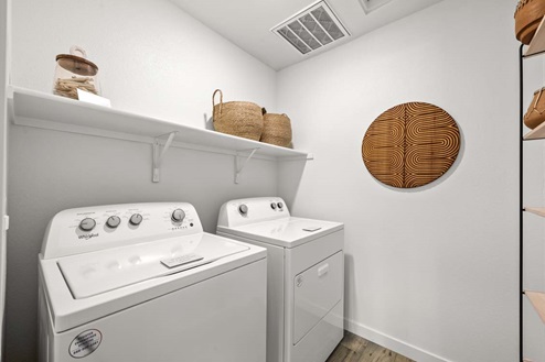 Amber Lynn Estates Plan 1547 Laundry room with shelving and washer and dryer.