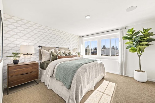Amber Lynn Estates Plan 1811 Large bedroom with side-by-side paned windows with full length curtains.