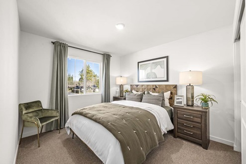 Amber Lynn Estates Plan 1811 Bedroom with paned window with full length curtains and closet.