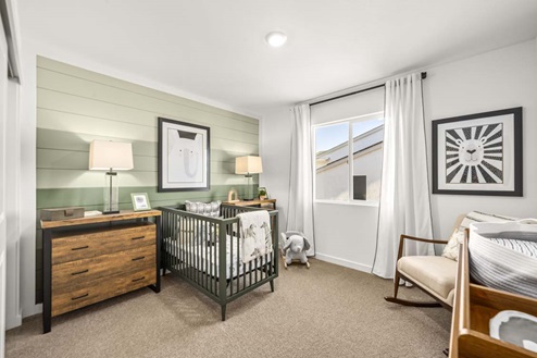 Amber Lynn Estates Plan 1811 Bedroom with window with full length curtains and green paneled wallpaper.