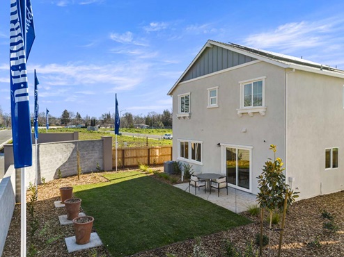 Amber Lynn Estates Plan 1811 Backyard patio and lawn with landscaping.