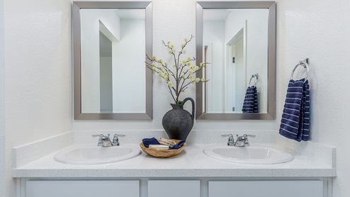Sleek primary bathroom with dual sink and mirrors