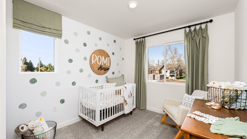 Spacious bedroom with wide paned window and floor length curtains
