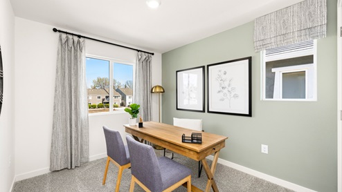 Spacious bedroom with wide paned window and floor length curtains