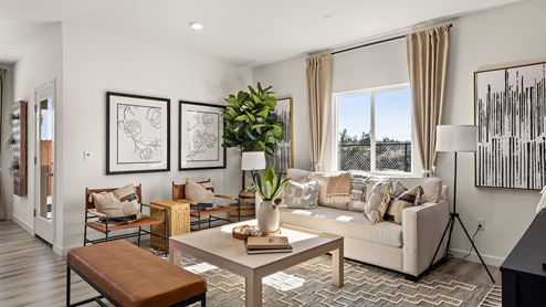 Spacious living area with window view of backyard and sliding glass door to patio