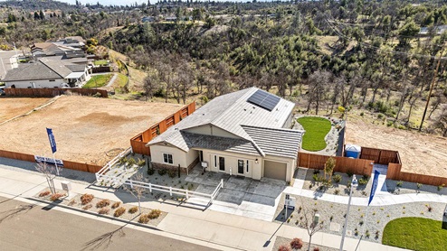 Single-story home with tan siding and two car garage.