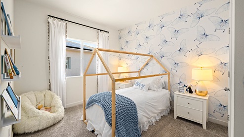 Spacious bedroom with wide paned window and floor length curtains