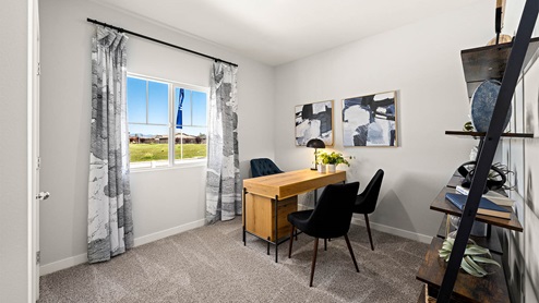 Spacious bedroom with wide paned window and floor length curtains