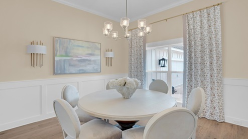 Dining room with window, wood floors and light walls.