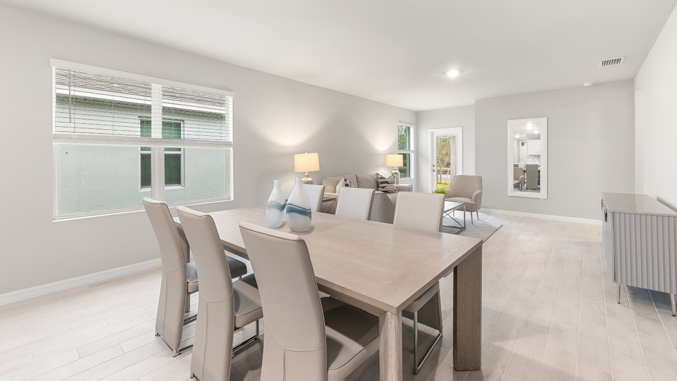 Inside the dining area of the Harper model. Plank tile flooring, grey walls, dining table with six seats.