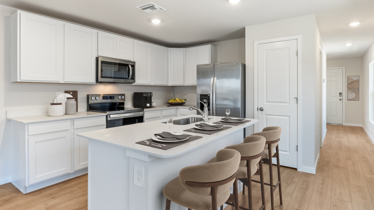 Inside of the kitchen. Stainless steel appliances, quartz countertops, walk-in corner pantry.