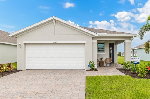 Outside of the Jemison model. Off-white home with two car garage, one window, and front door. Mixed paver driveway.