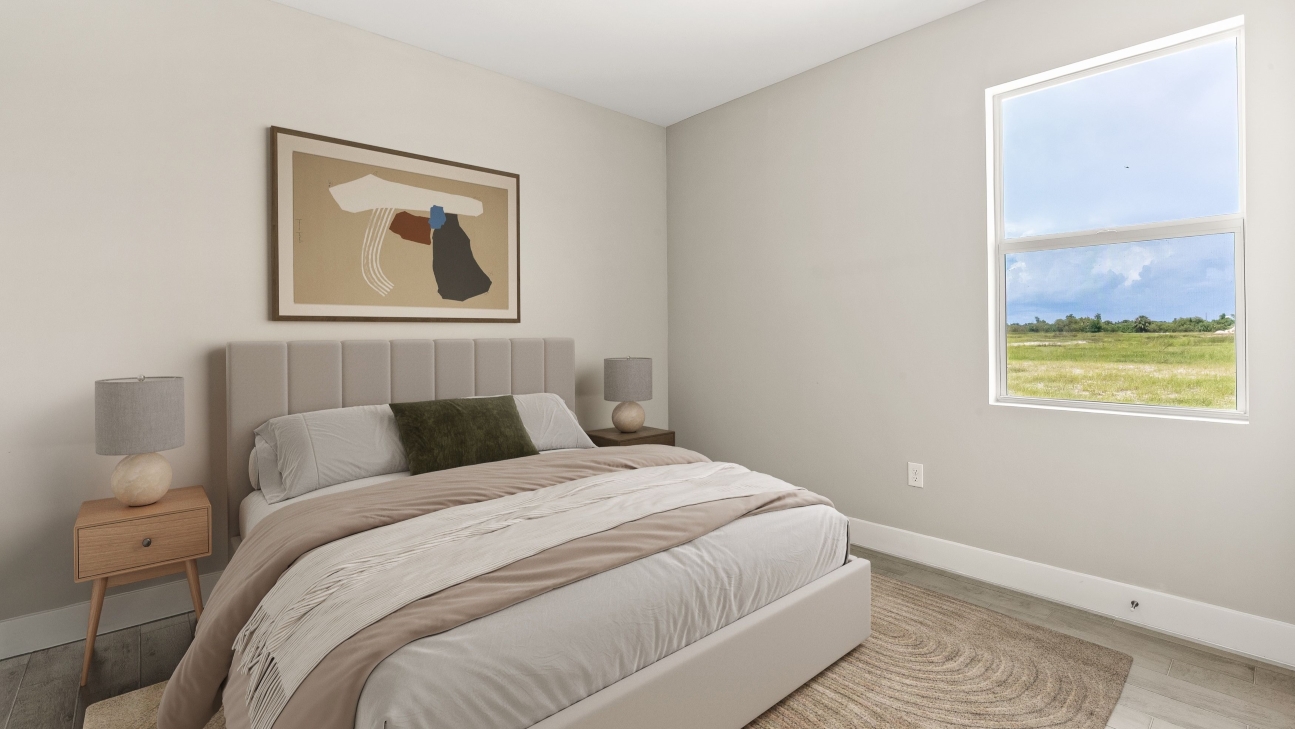 Inside of the Shelby model third bedroom. Bed with side tables and decor.