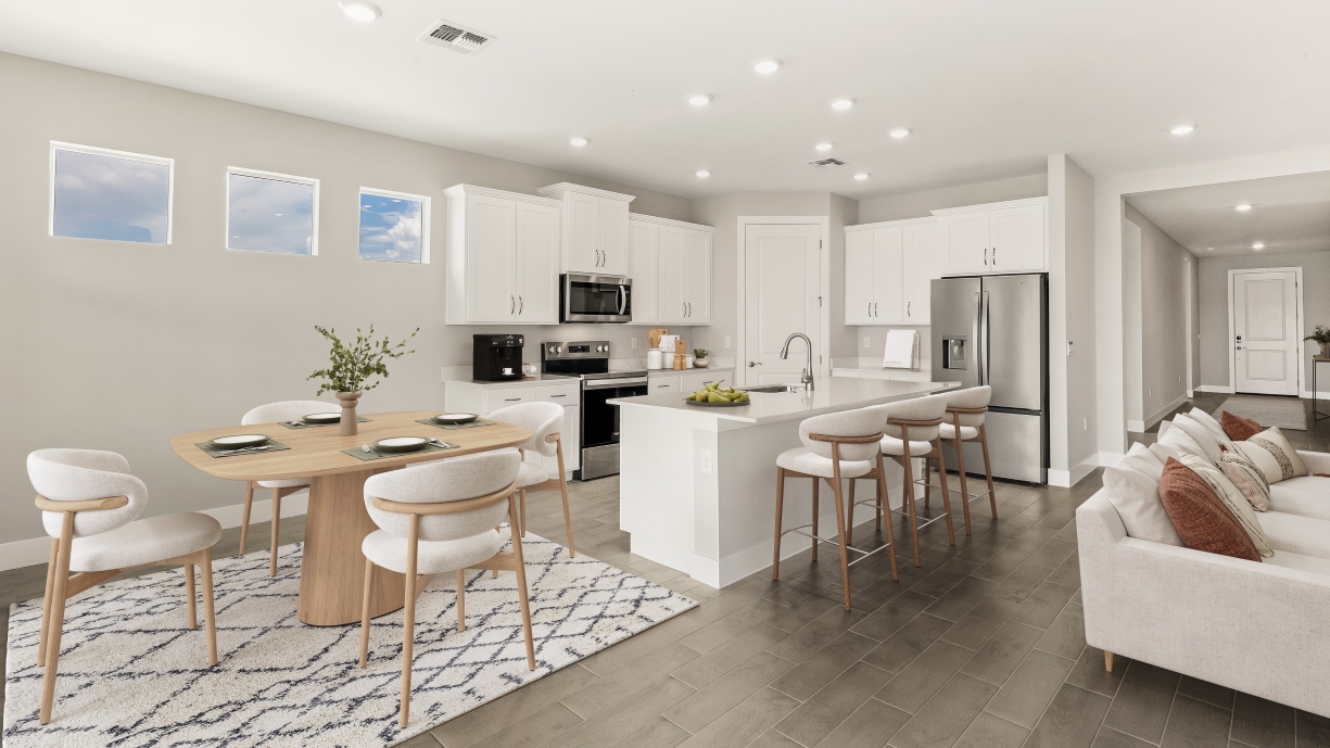 Inside of the Shelby model home Kitchen with stainless steel appliances. Living room couch from this angle and dining area.