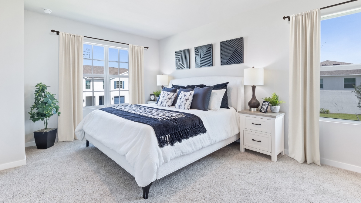 Inside bedroom one of the Pearson model. Contains a large bed with nightstands on either sides.