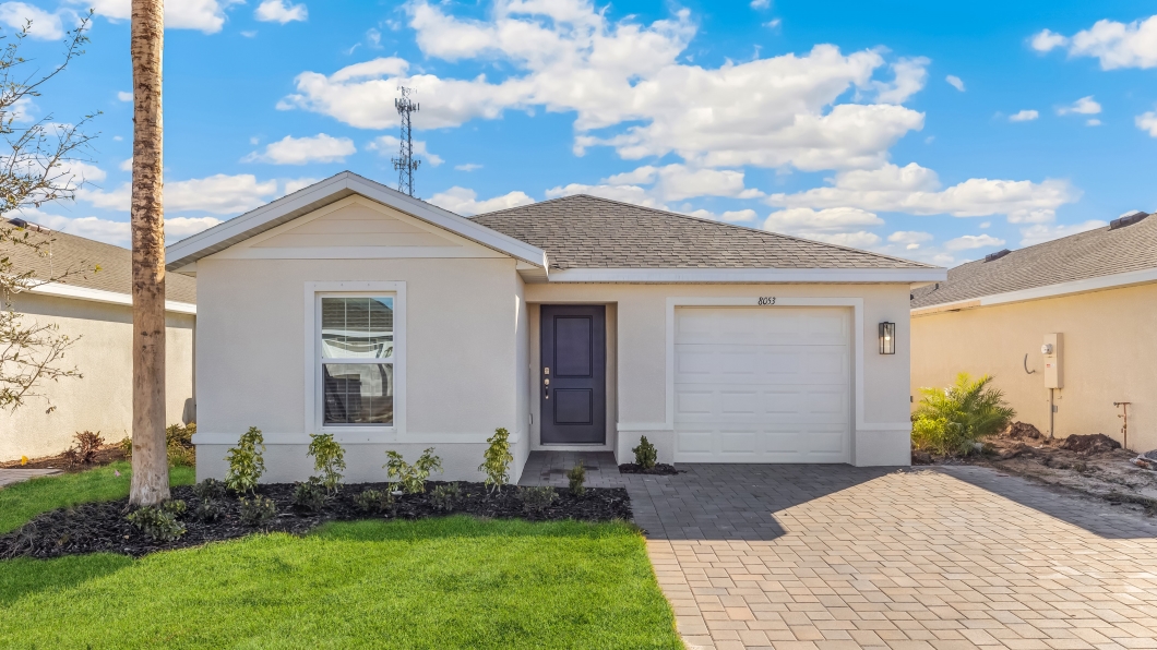 Outside of the Cameron B model. Light home with a 2 car garage, window, and mixed paver driveway.