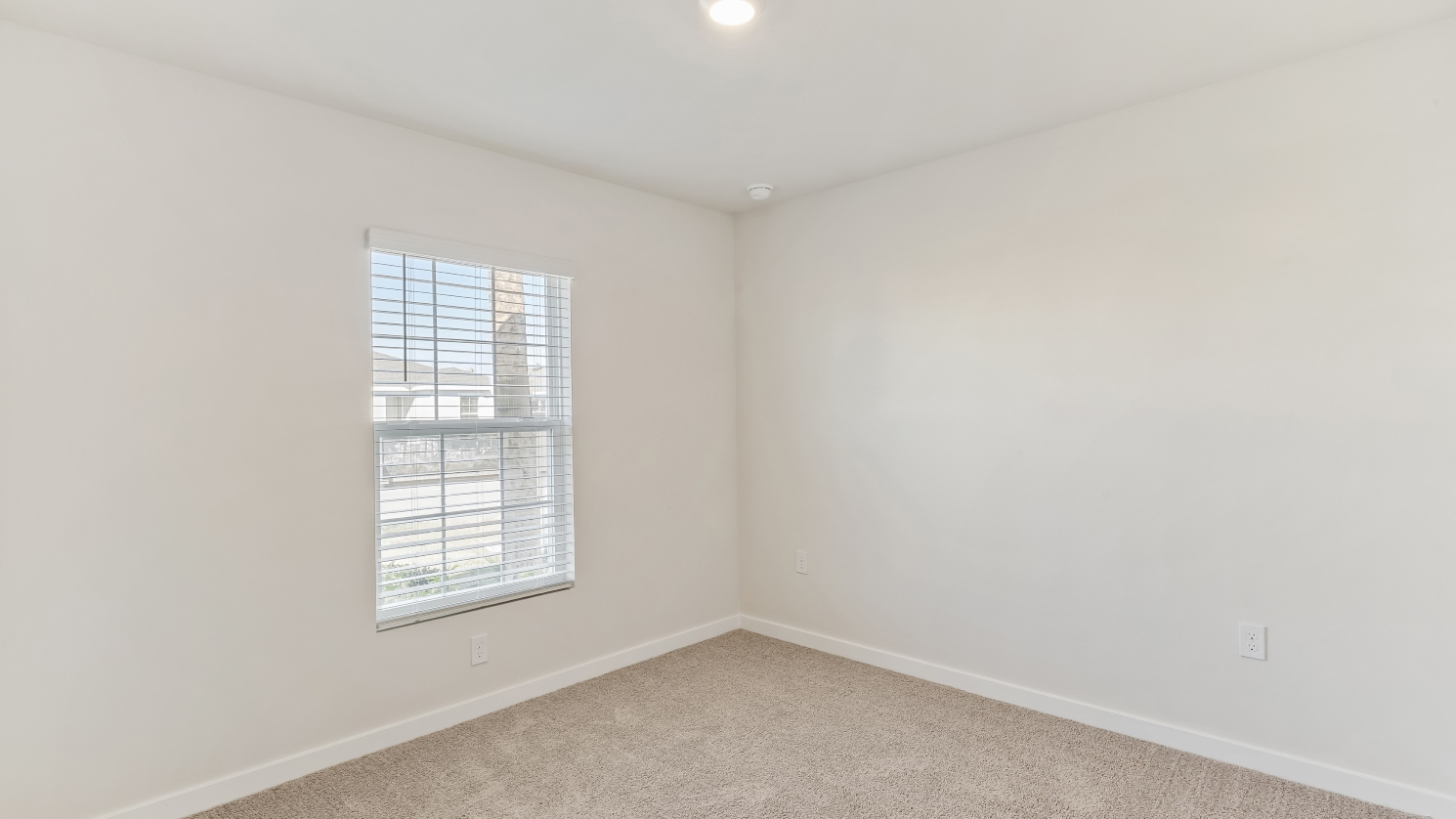 Inside of the Cameron B mocel bedroom. Off-white carpet with white walls.