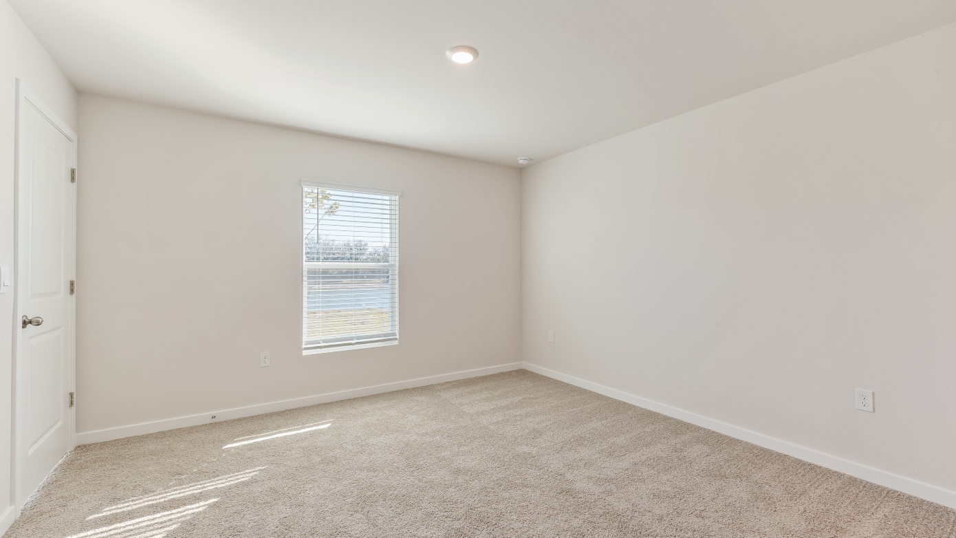 Inside of the Cameron B mocel bedroom. Off-white carpet with white walls.