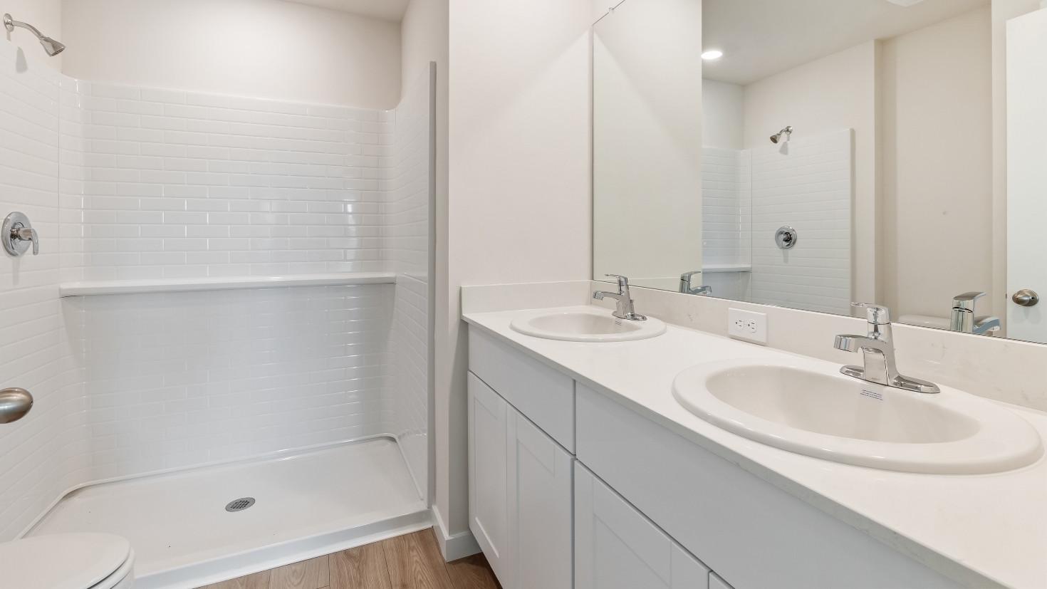 Inside of the Cameron B model bathroom 2. White cabinets and countertops with a white shower.