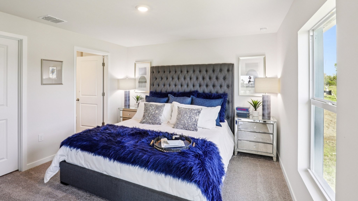 Inside of the Cameron B model bedroom. Off-white carpet with white walls.