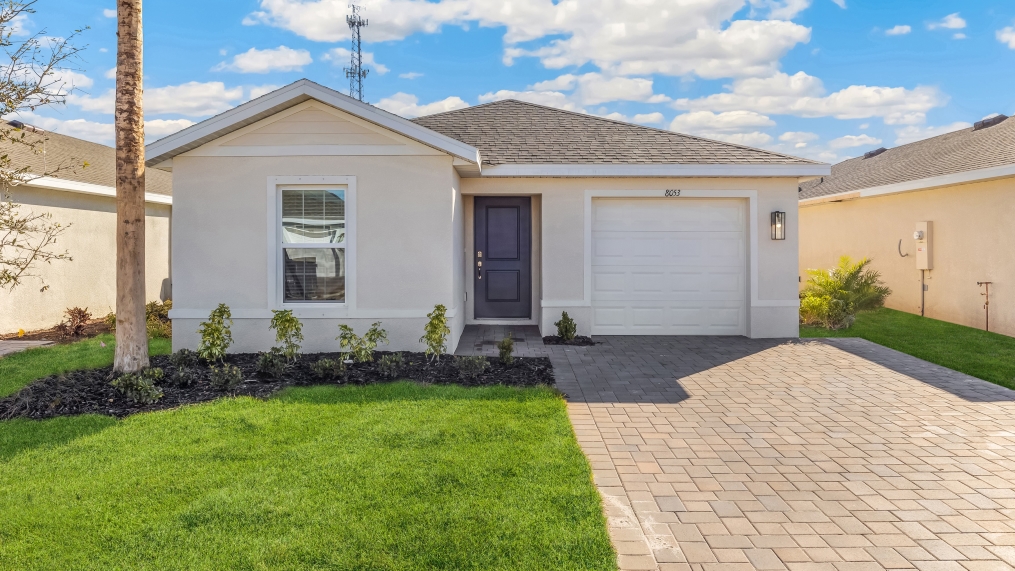 Outside of the Cameron model. Light home with one car garage, window, front door, and mixed paver driveway.